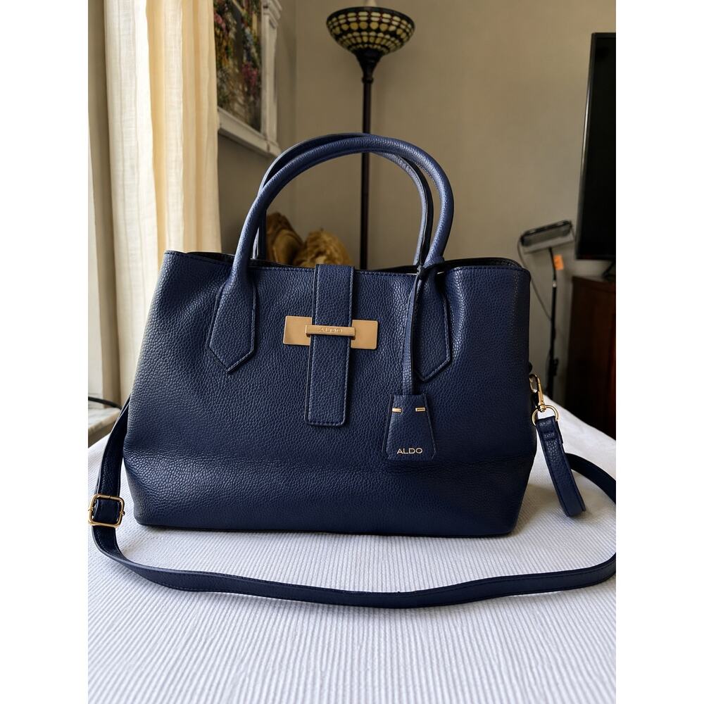 blue ALDO handbag features a prominent gold-tone logo clasp and a structured
